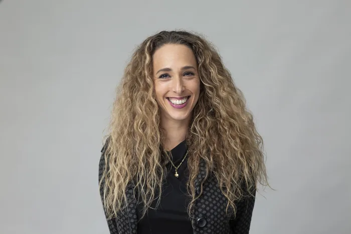 הדס דרור בצילום סטודיו, לובשת ז'קט מנוקד כהה